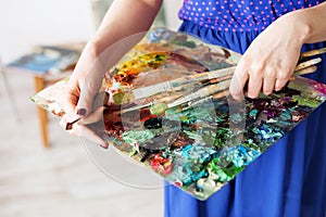 palette with paintbrush and palette-knife in artistÃ¢â¬â¢s hands. photo